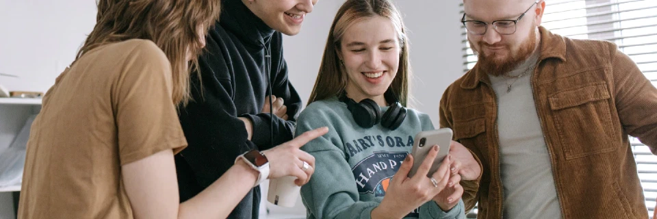 group viewing mobile phone interacting
